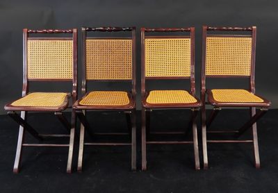 quatre chaises avec des assises en osier et des dossiers en rotin, sur fond noir