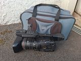 a camera and a bag on the ground near a building