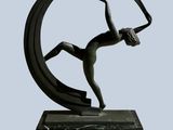 bronze sculpture of a woman holding a circular object on a marble base