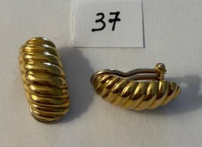paire de boucles d'oreilles dorées présentant un motif torsadé sur fond blanc