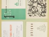 four business cards with different designs on them sitting on a table