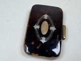 a small tortoise shell case with a picture on it
