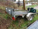a trailer with a trailer attached to it in the grass
