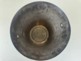 a silver vase with a hole in the middle of it