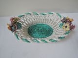 a white and green bowl with flowers in it on a table