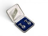 a pair of cufflinks in a silver case with blue velvet lining