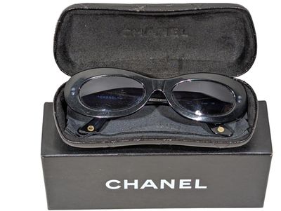 une paire de lunettes de soleil dans un étui, sur fond blanc