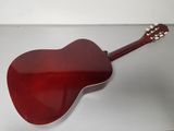 a close up of a red acoustic guitar on a white surface