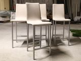 three white chairs that are sitting on a concrete floor