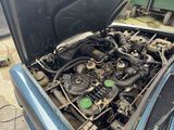 a blue car with its hood open and the engine in the trunk