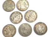 six different types of silver coins on a white surface