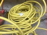 a yellow hose sitting on the ground next to a red fire hydrant