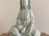 a small statue of a person sitting on a table
