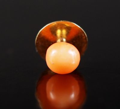 Bouton de col en or jaune 750, serti de corail en cabochon.