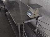 stainless steel counter top in a commercial kitchen with a digital scale on it