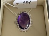 an image of a purple stone pendant in a box with a price tag