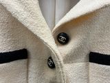 une photo d'une blouse blanche à boutons noirs