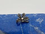 un gros plan d'une bague posée sur une pierre bleue