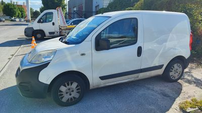 une petite camionnette blanche garée sur le bord de la route