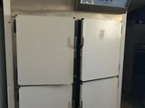 two white refrigerators in a kitchen next to a trash can