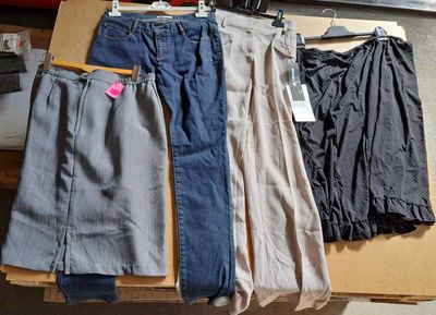 plusieurs paires de pantalons posées sur une table à côté d'un appareil photo