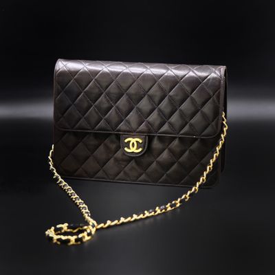 a black chanel bag with gold chain on a black background