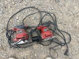 two electric tools on the ground next to a pair of shoes