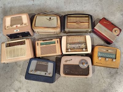 many old radio ' s sitting on the floor next to each other