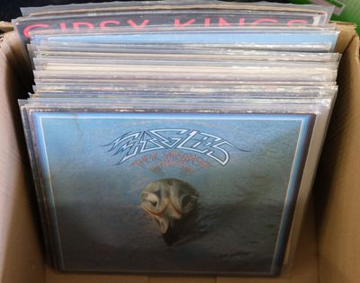 une boîte remplie de CD et des CD posés sur une table