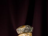an old hammer with a rock on it sitting on top of a wooden stick