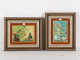 deux tableaux encadrés représentant des fleurs et des vases accrochés à un mur blanc