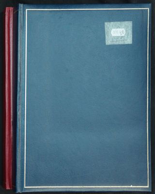 un livre bleu ouvert, à la couverture rouge, posé sur une table
