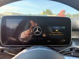 the view of a car ' s dashboard from the driver ' s seat with the mercedes logo on the screen