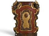 un vase rouge et doré sur lequel figure une image de Jésus