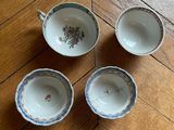 three cups and saucers sitting on a wooden floor next to each other