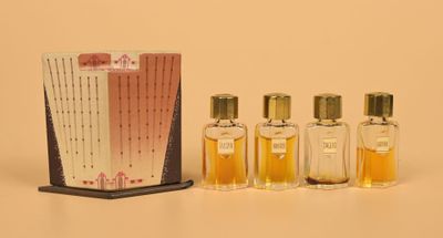 three small bottles of perfume sitting next to a box of perfume