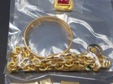a gold bracelet, ring, and other jewelry in a plastic bag