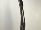 sculpture représentant un morceau de bois courbé posé sur un socle blanc