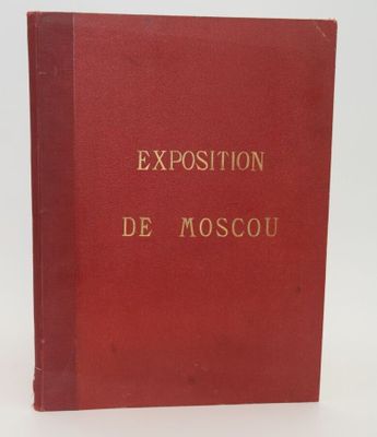 un livre rouge avec des lettres dorées posé sur une surface blanche