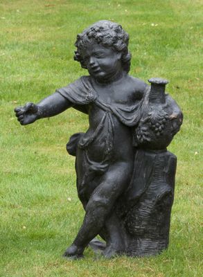 une statue représentant un garçon avec un oiseau posé sur une souche