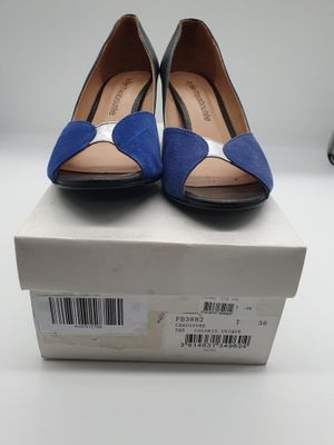 des chaussures bleues et noires posées sur une boîte, sur une surface blanche