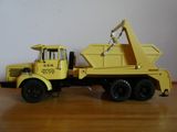 un camion jouet jaune équipé d'une grue à l'arrière
