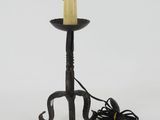 a black candle holder with a yellow candle on it