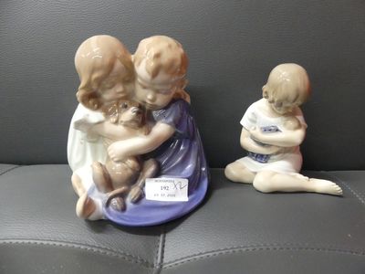 two figurines of children sitting on a couch