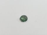 a green tourmaline gems on a white surface