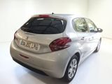 the back of a silver car is parked in a white room