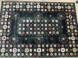 a close up of a black and white rug with buttons on it