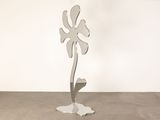 a metal sculpture of a flower on a stand