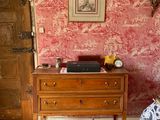 a bed and a dresser in a room with a red wall