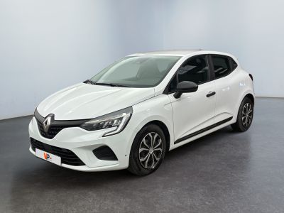 Une voiture blanche est garée dans une pièce au sol noir.